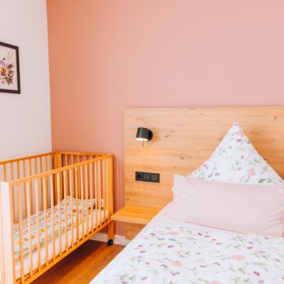 Elternschlafzimmer mit Gitterbett der Wohnung Himbeere